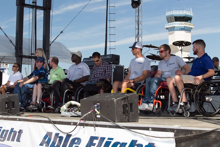 Pilots whose training was funded through Able Flight prepare to accept their wings at EAA AirVenture. They are, from left, Johnny Ragsdale, Shavon McGlynn (standing), Scott Early, Justin Falls, Shafeeq Moore (who soloed a week before the event and will complete his training in 2017), Bernard Dime, Trevor Denning, Ethan Daffron, and Chris Sullivan. Jim Moore photo.