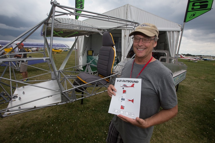 Randy Schlitter with his new design, and the beginnings of the S-21 on display at EAA AirVenture. Photo by Jim Moore.