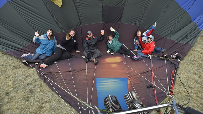 Montana balloonist Colin Graham's crew members wave while they trap hot air in the envelope behind them during the Albuquerque International Balloon Fiesta, Oct. 8. Photo by David Tulis.