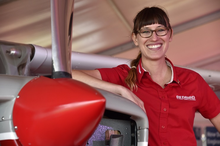 Redbird's Winging It video host Brittney Miculka's next challenge involves steering more than 100 flight instructors, educators, and flight school managers through Redbird Flight Simulations' annual Migration conference in Texas. Miculka is shown at the Redbird booth during EAA AirVenture 2016 at Wittman Regional Airport in Oshkosh. Photo by David Tulis.