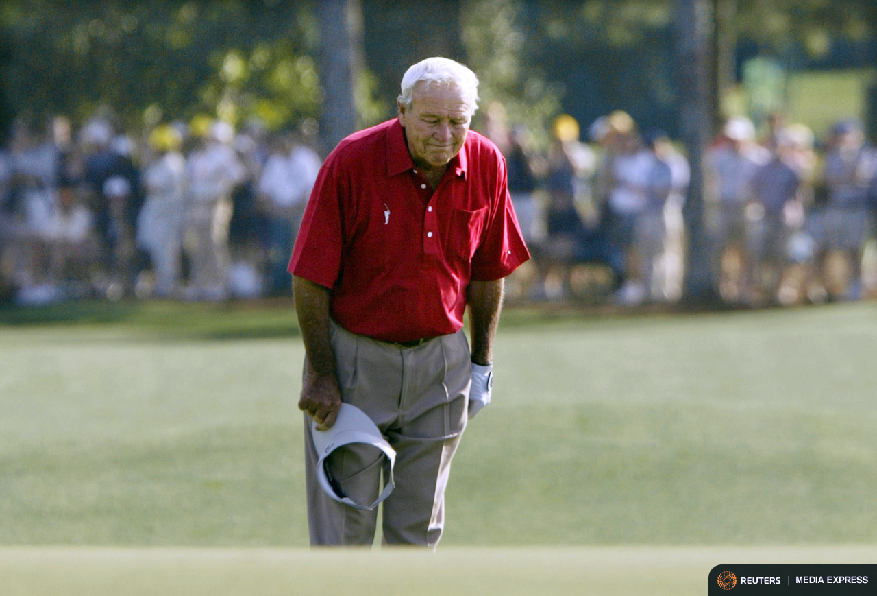 Arnold Palmer pauses and bows to patrons as he walks to the 18th green in 2004 during his final competitive appearance in the Masters golf tournament at Georgia's Augusta National Golf Club. Photo by Kevin Lamarque/REUTERS.