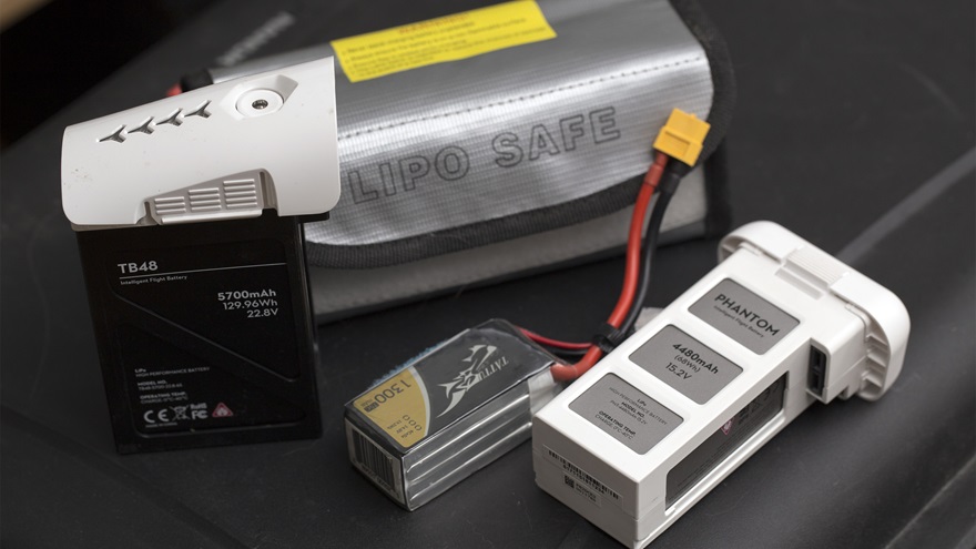 A range of batteries for different types of drones: a DJI Inspire 1 (left), a racing quadcopter (center), and a DJI Phantom 3 (right). A battery bag like the one shown here is appropriate for smaller batteries, but unlikely to contain the energy stored in the Inspire battery. Jim Moore photo.