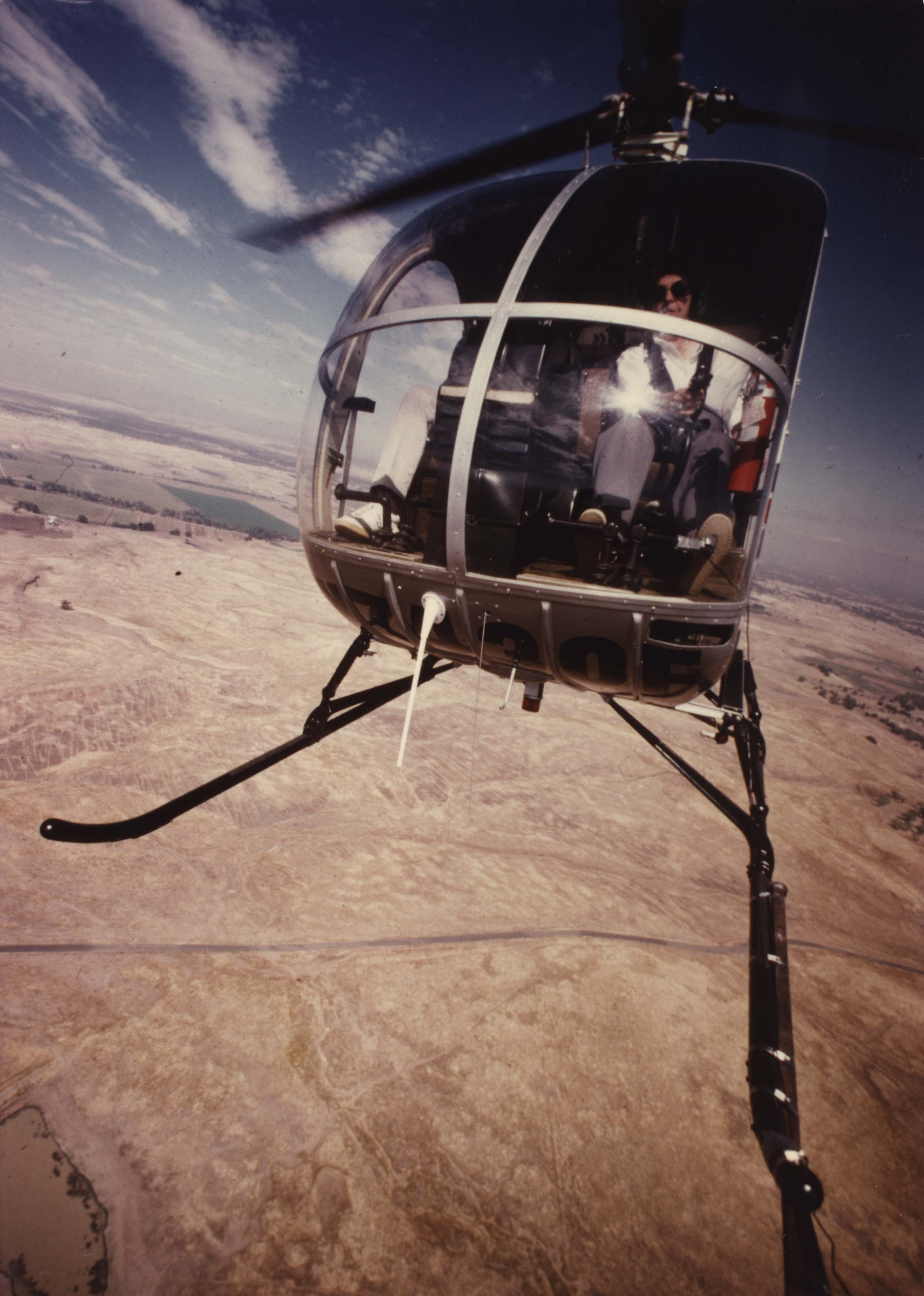 Doris Lockness (WG #55) in a Hughes 300. This photo is a self-portrait taken from a camera attached to the helicopter skid. Courtesy of the TWU Libraries Woman's Collection, Texas Woman's University, Denton, TX.