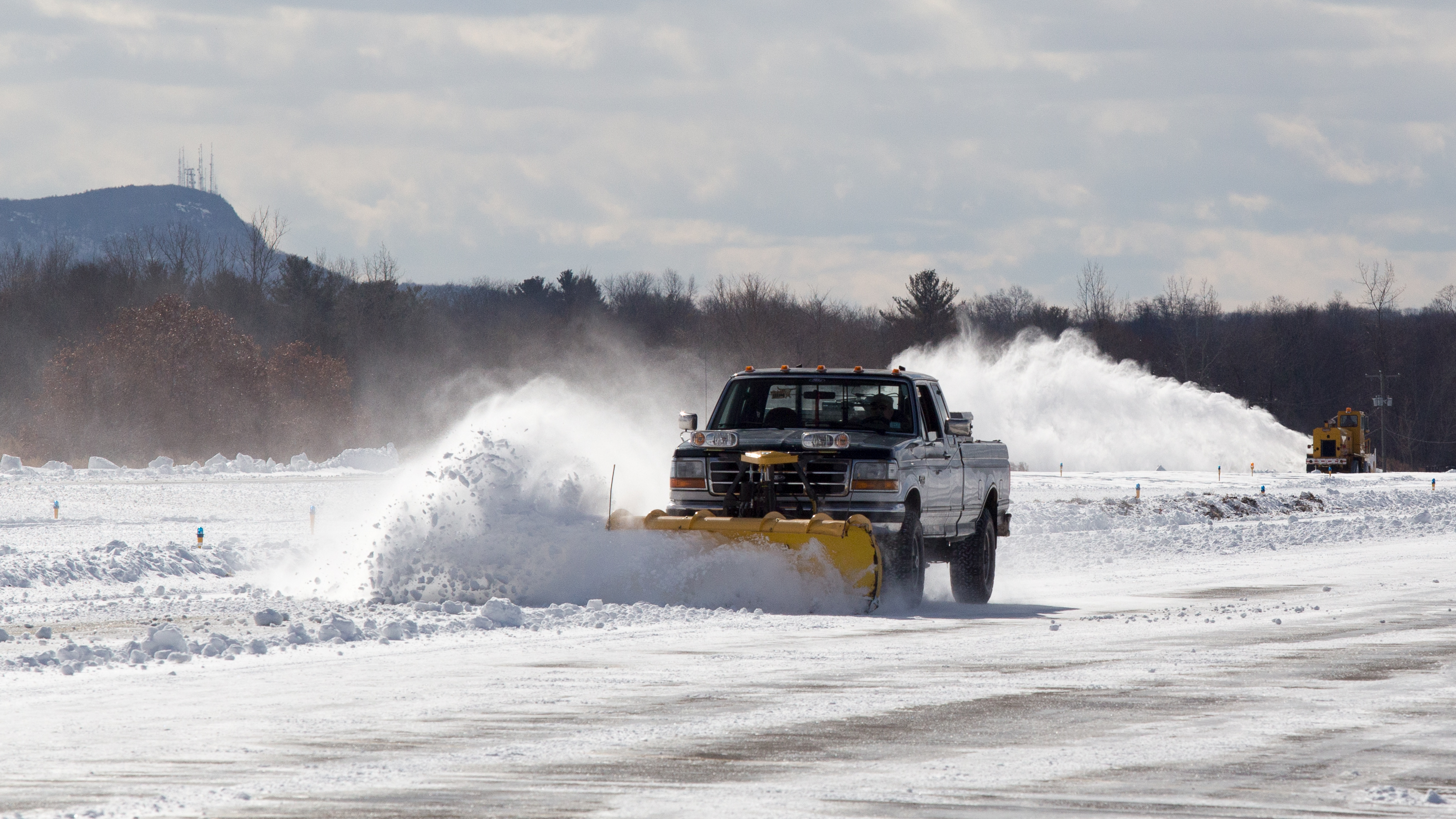Airport manager Bill O'Leary plows with a pickup while one of his employees clears the runway with an SMI Snowmaster on Feb. 10. Jim Moore photo.