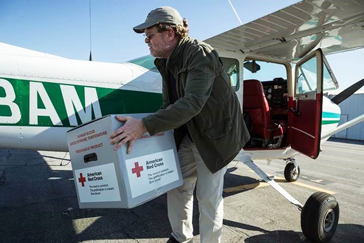 Flight instructor Chris Irwin unloads a box of American Red Cross supplies from the Glendale Community College airplane he had flew in from Whiteman Airport in Los Angeles. Photo courtesy of the Disaster Airlift Response Team.