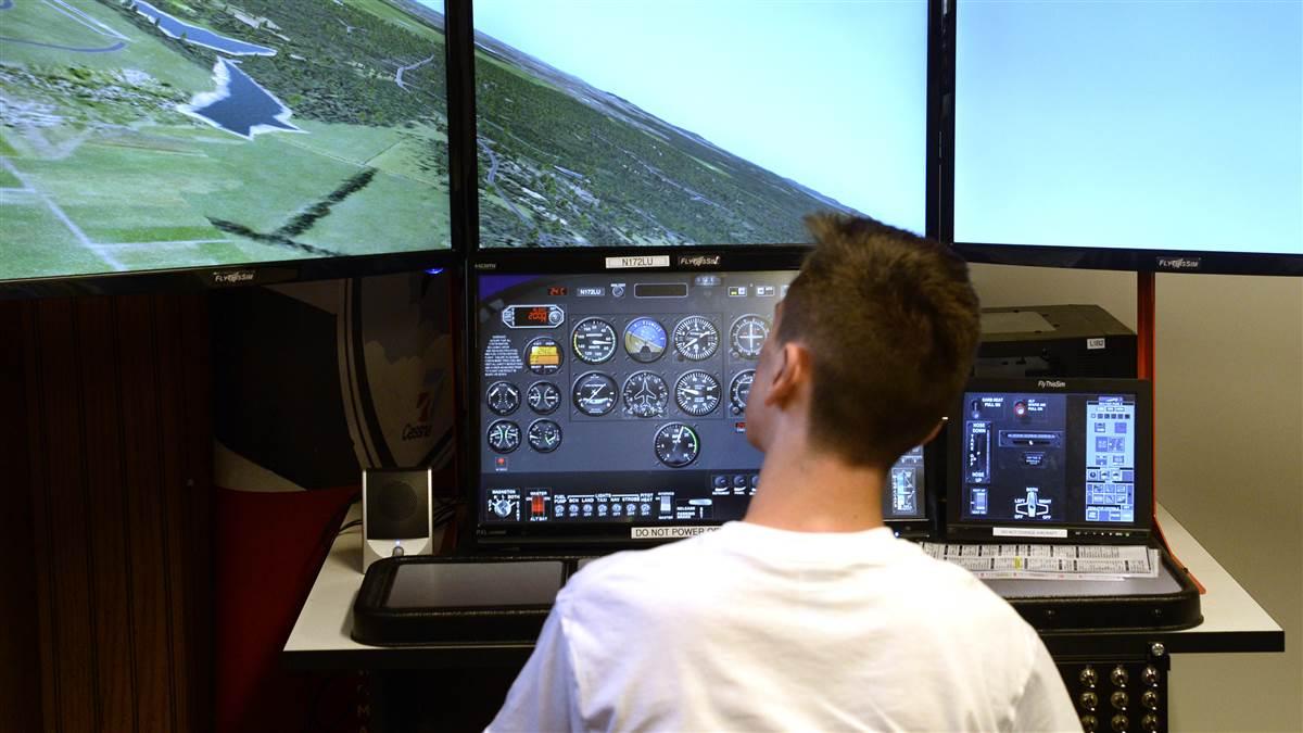Student pilot Joel Cihak uses a flight simulator computer to practice landing at Virginia’s New London Airport during a 2016 Liberty University solo camp for high school youth. Photo by David Tulis.