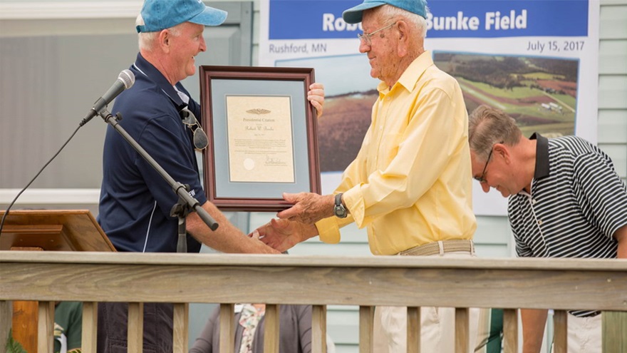 AOPA President Mark Baker presents Robert Bunke a Presidential Citation for "his leadership and contributions to general aviation in bringing an airport to his hometown." Photo courtesy of Shannon Meier Photography.