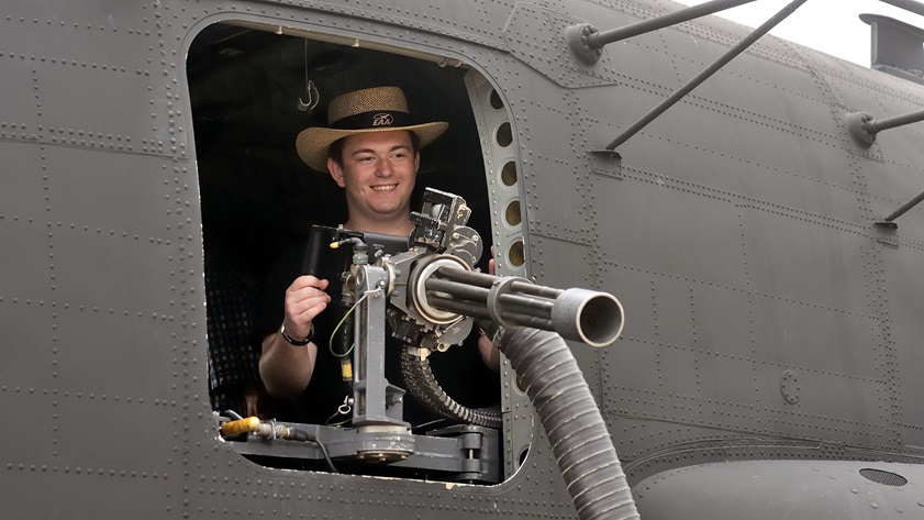 Randy Butt, 17, of Wilmington, North Carolina, poses behind a minigun in a MH-47C heavy assault helicopter. His father, Michael Butt, wanted to re-create a photo taken when Randy was five. The helicopter is operated by the U.S. Army's 160th Special Operations Aviation Regiment. Photo by Mike Collins.