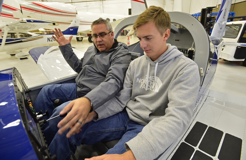 Phillip Campbell familiarizes a Van's Aircraft RV-12 cockpit with McKinney High School student Bryan Soltys-Niemann during an aviation class at McKinney National Airport in McKinney, Texas. The school helped field test AOPA's high school aviation STEM curriculum. Photo by David Tulis.