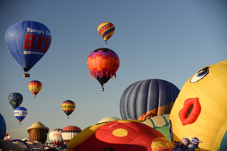 Balloonists lift off during a mass ascension at the 2016 Albuquerque International Balloon Fiesta. Photo by David Tulis.