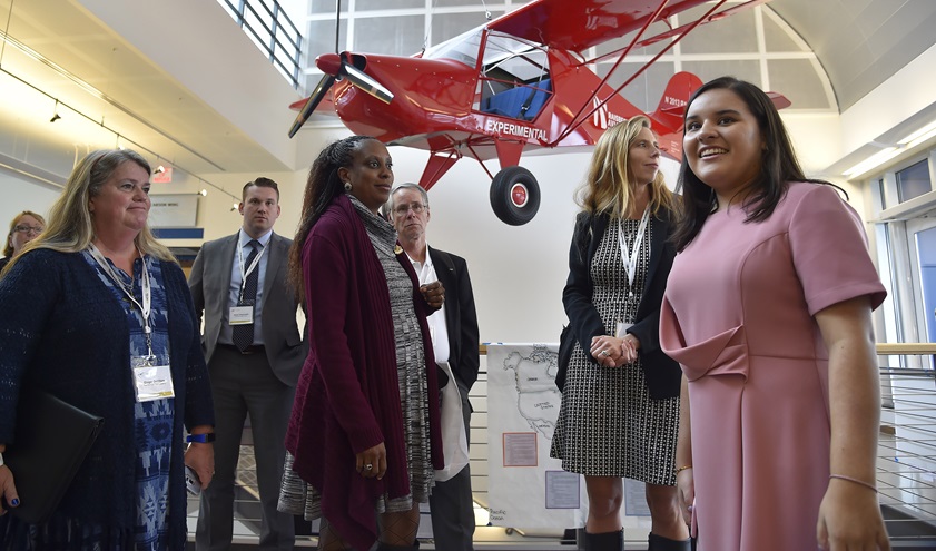 An Avid Flyer provides the background as Raisbeck Aviation High School student Nicole Diaz leads 2016 AOPA High School Symposium attendees on a tour. Photo by David Tulis.
