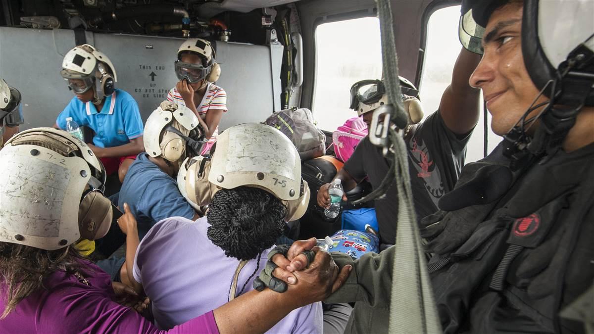 U.S. Navy Petty Officer 1st Class Erick Sotelo comforts an evacuee in a flight from Dominica, Sept. 25, following Hurricane Maria. U.S. Navy photo courtesy of Petty Officer 3rd Class Sean Galbreath.