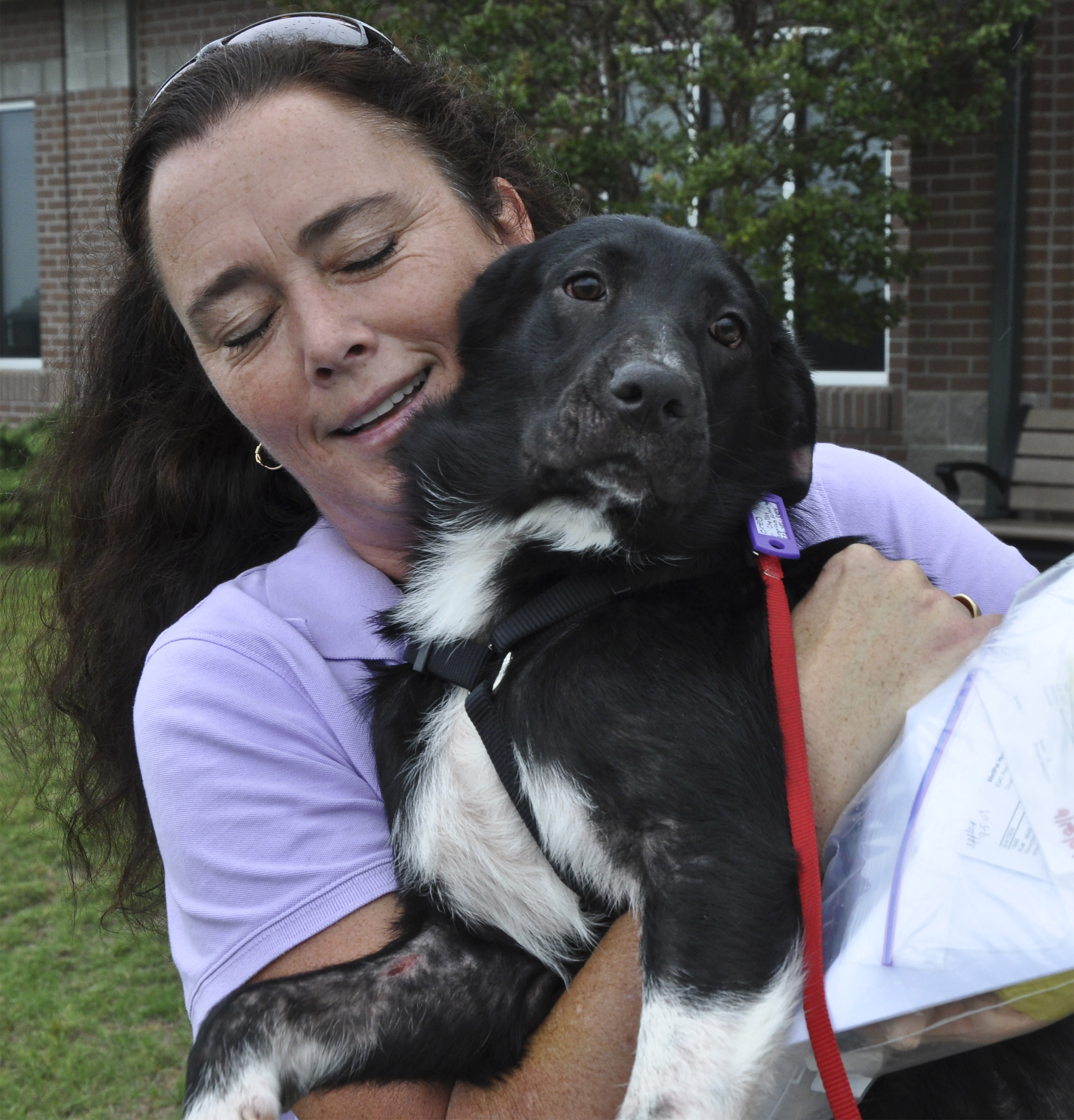 Oreo, a six-month-old female border collie, gets a last hug from her foster human Sabrina Sweeney-Garcia, who rescued Oreo from a north Georgia facility before the animal was to be put to sleep. Pilots N Paws is a volunteer organization that matches pilots and their aircraft with animals in need of new homes. Photo by David Tulis.