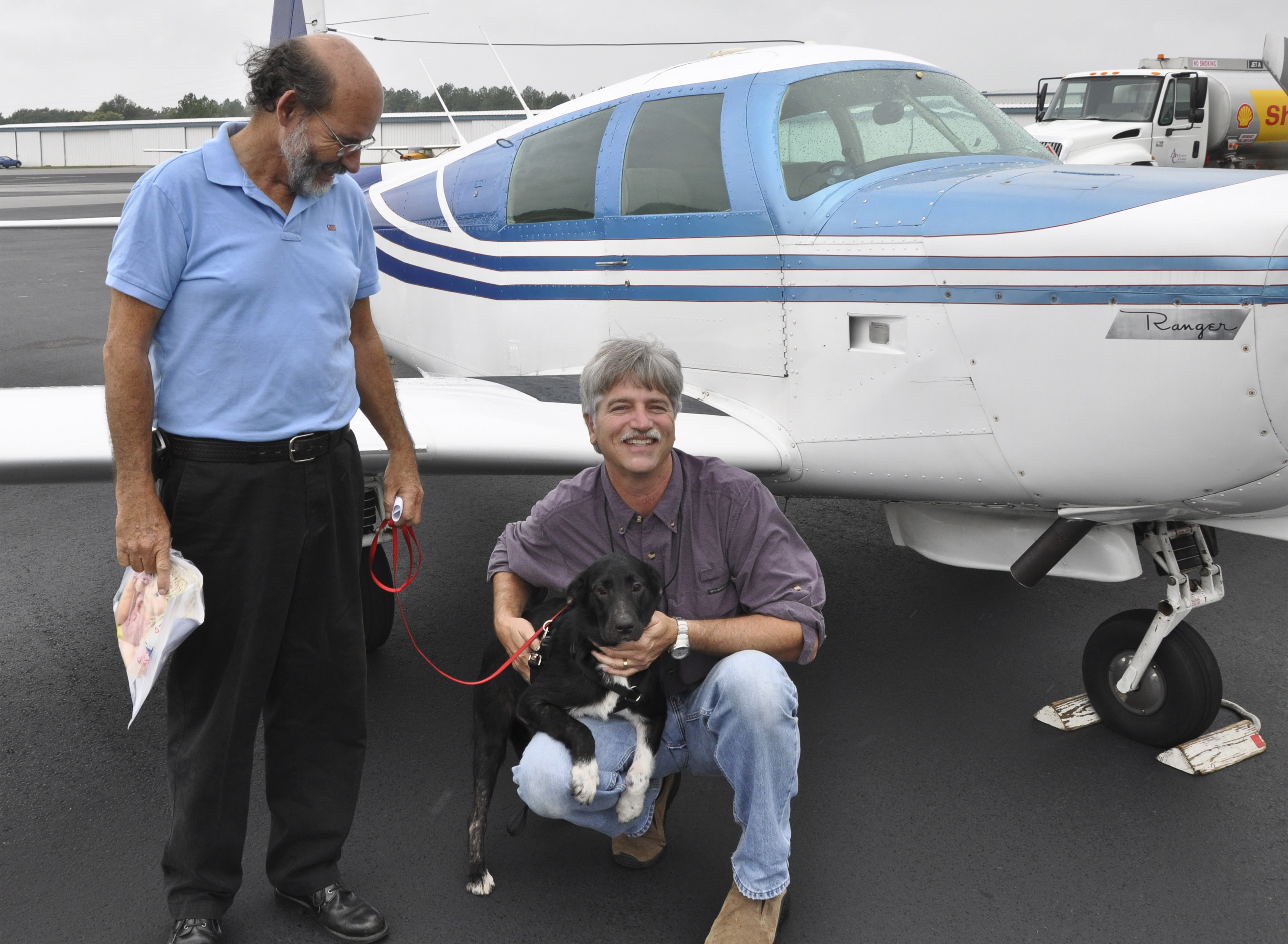 Pilot David Tulis and Skybound Aviation flight instructor Michael O'Neal of Atlanta prepare to transport a border collie named Oreo on a Pilots N Paws relocation mission in Tulis's Mooney M20C Ranger. Photo by Sabrina Sweeney-Garcia.