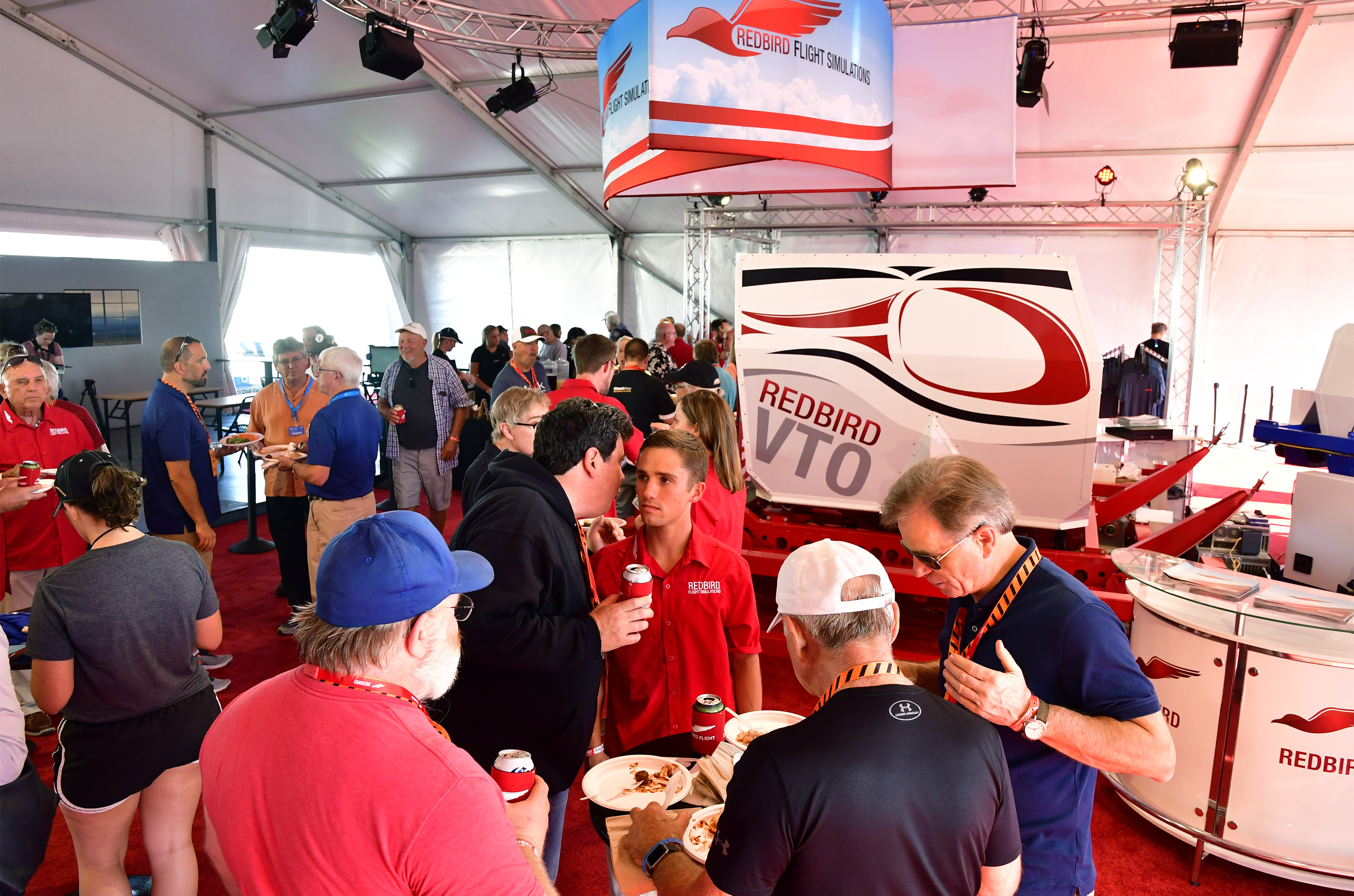The booth at Redbird Flight Simulations draws a crowd at EAA AirVenture on July 22. Photo by David Tulis.