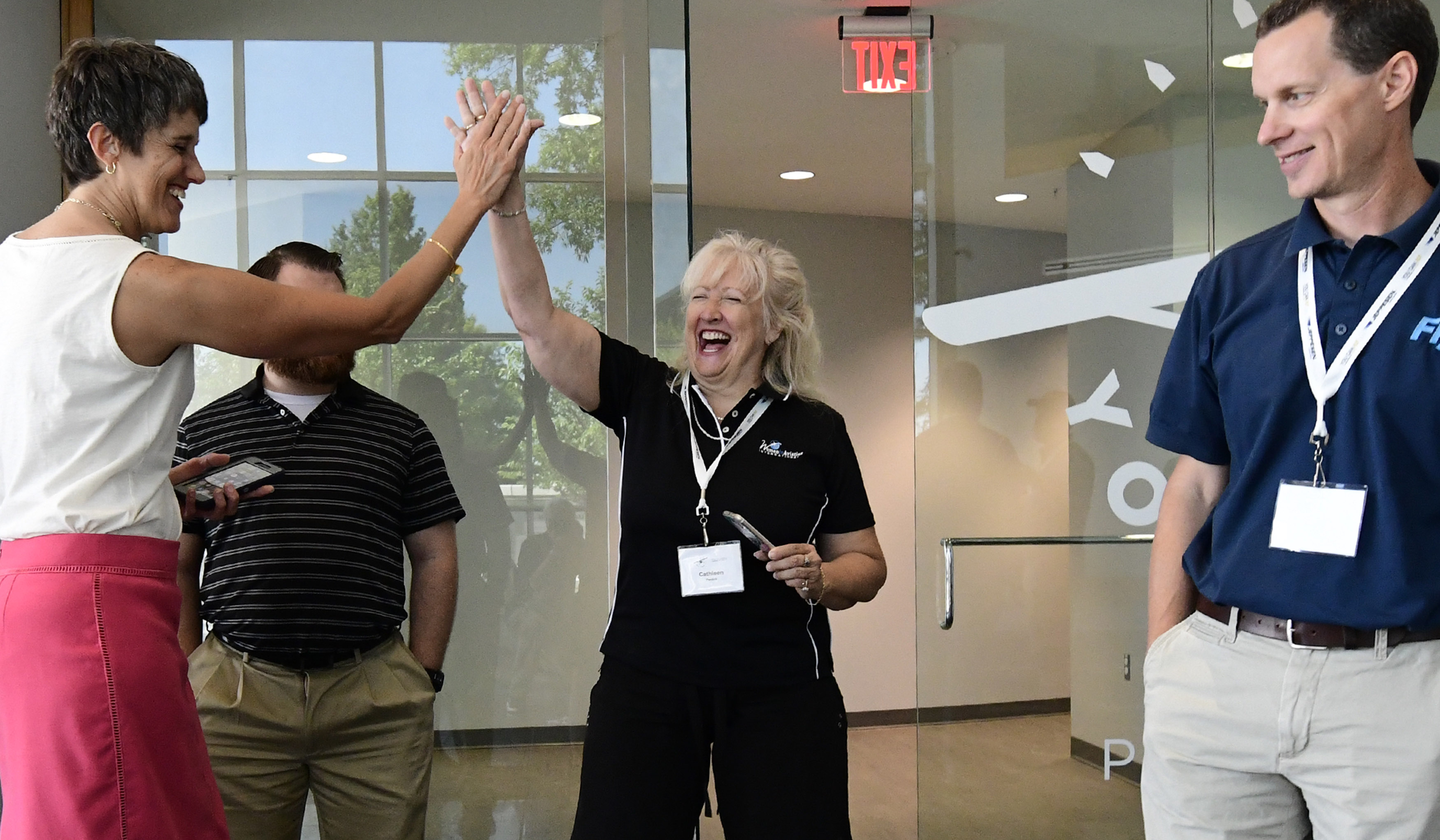 High school teacher and helicopter instructor Cathleen Perdok is congratulated by Cindy Hasselbring, AOPA senior director of the high school initiative, after flying a small drone to its landing station during an introduction of the AOPA You Can Fly tenth-grade science, technology, engineering, and math aviation-based curriculum. Photo by David Tulis.