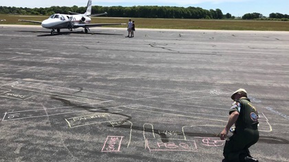 AOPA Airport Support Network volunteer Graeme Smith traced the outline of Newport State Airport’s runways in chalk to give visitors a pilot's perspective. Photo by Sean Collins.
