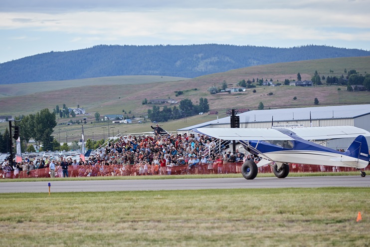 A crowd gathers for a short takeoff and landing demonstration during the AOPA Fly-In at Missoula, Montana. Photo by Mike Fizer.