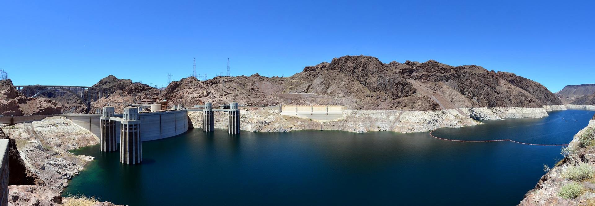 This panoramic view of Hoover Dam from the Arizona side shows the penstock towers, the Nevada-side spillway entrance and the Mike O'Callaghan—Pat Tillman Memorial Bridge. Note the “bathtub ring” due to low water levels, now lower than when this photo was taken in 2011. Ongoing drought and climate change will likely further reduce reservoir levels, already below 40 percent capacity. Photo by Crista Worthy.