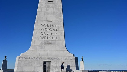A youth explores the 60-foot monument at Kill Devil Hills at the Wright Brothers National Memorial in Kitty Hawk, North Carolina. A new visitors center, interactive exhibits, and a look at their bicycle building background await visitors to the Outer Banks memorial. Photo by David Tulis.