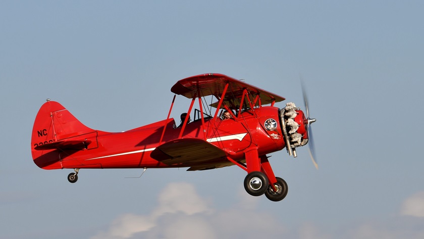 Sophie LeGore's smile can be seen from the ground as she lifts off in Cliff McSpadden's 1941 Waco UPF-7, "Georgia Girl," at AOPA's 2018 Carbondale Fly-In. She is a senior in Southern Illinois University Carbondale's aviation technologies program and works at the airport's FBO. Photo by Mike Collins.