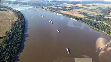 Barges line up in the middle of the Ohio River waiting for towboats.