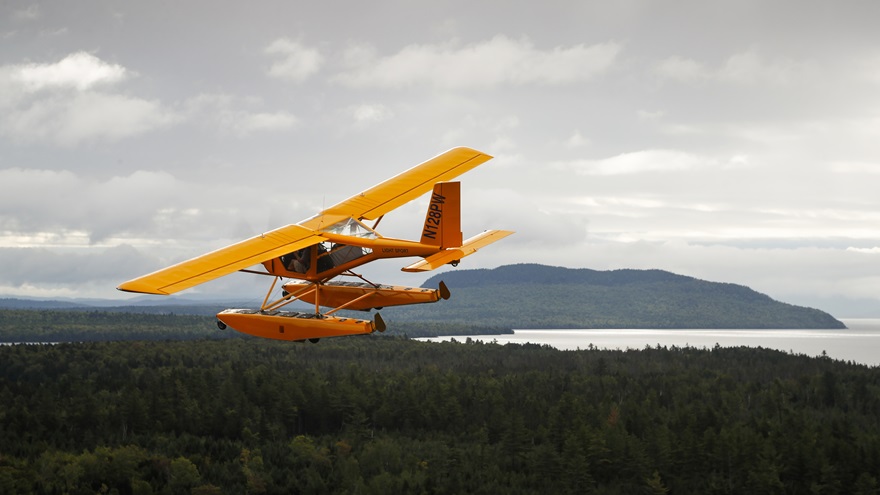 A seaplane flies over Maine's remote landscape heading to Greenville for the International Seaplane Fly-In at Moosehead Lake. Photo by Chris Rose.