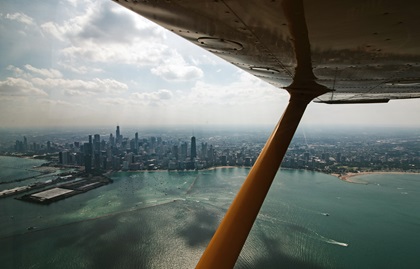 The Chicago skyline is framed by the strut and wing of a Cessna 172 after departing EAA AirVenture July 28. Photo by Kevin Cortes.