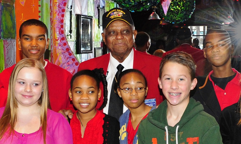 Tuskegee Airman Robert T. McDaniel, center, poses with local youth during a 2012 celebration for the film 'Red Tails,' based on the first all-black squadron of bombers, pilots, and maintenance personnel in the Armed Forces during World War II. Photo courtesy of Senior Airman Martha Whipple, U.S. Air Force.