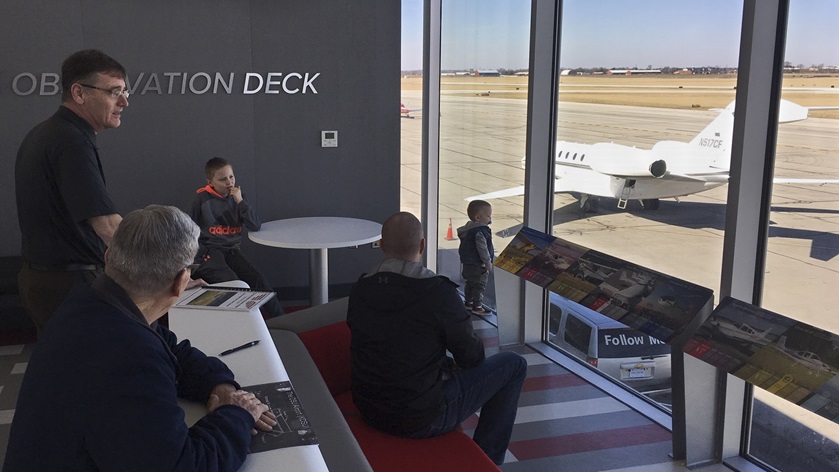 Guests watch takeoffs and landings from an observation area at a new terminal and education center at Ohio State University Airport during a recent open house. Photo by Kyle Lewis.