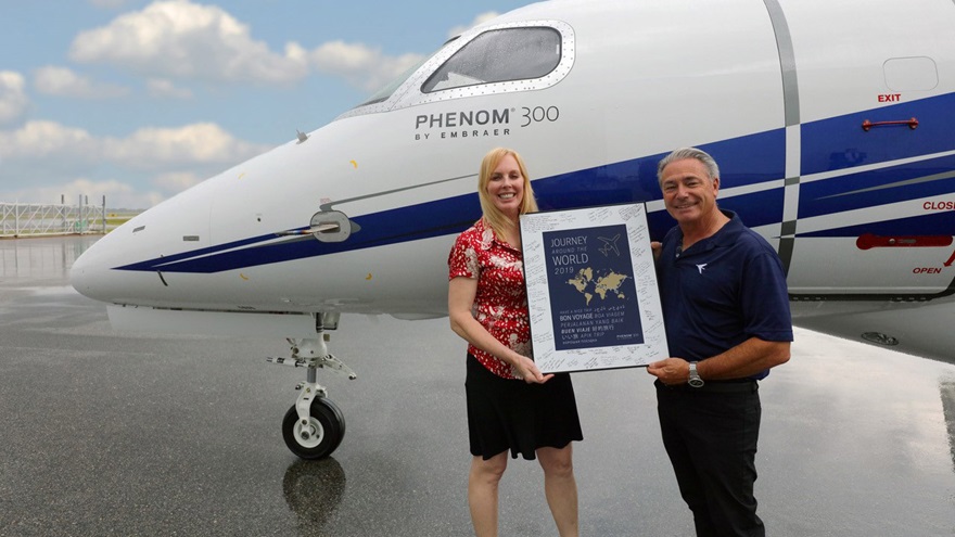Lance Mortensen prepares to round the globe single-pilot in his Embraer Phenom 300 jet, accompanied by Natasha Hawkins and here displaying "bon voyage" greetings from well-wishers at Embraer's Melbourne, Florida facility. Photo courtesy of Embraer.