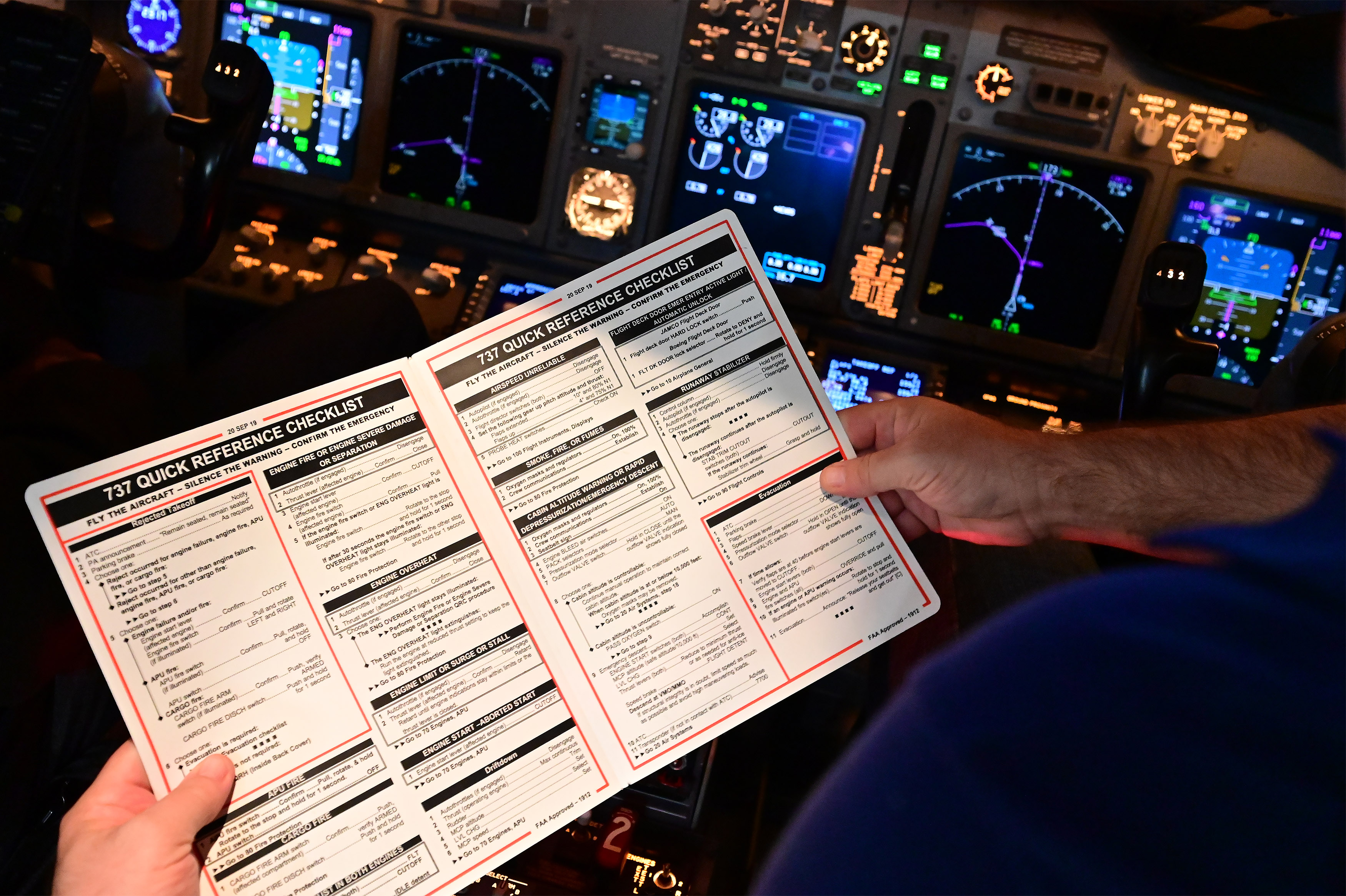 High school aviation teacher Kevin Moss reads a Boeing 737 quick reference checklist. Photo by David Tulis.