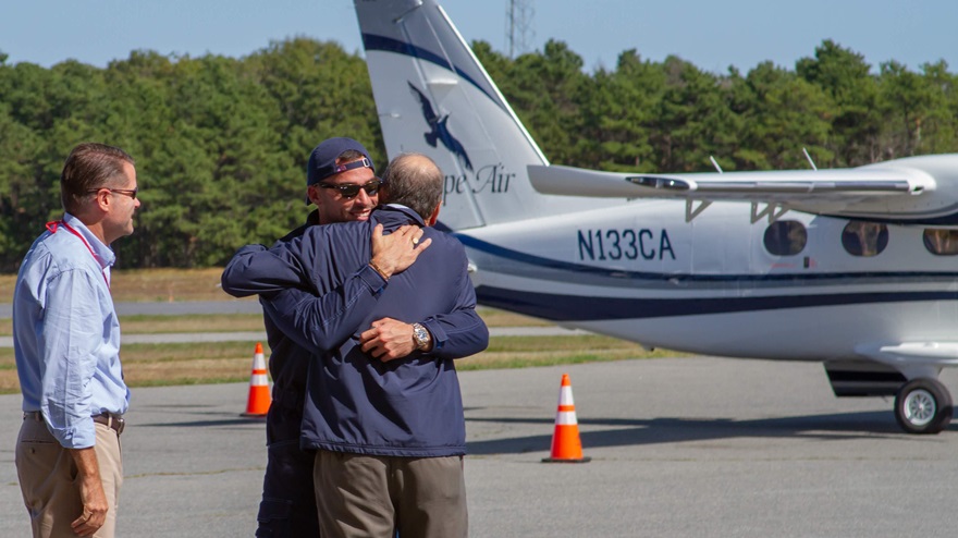 Tecnam Managing Director Giovanni Pascale and Cape Air Founder and CEO Dan Wolf celebrate the arrival of the first new Tecnam P2012s in Hyannis, Massachusetts, with a big hug, as Cape Air Senior Vice President James Goddard looks on. Photo courtesy of Tecnam. 