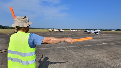 Volunteer Carlos Orellana of Lakeland, Florida, marshals an aircraft to parking at AOPA's Tullahoma Fly-In. He and his wife flew her Cherokee 140 to Tennessee. Photo by Mike Collins.