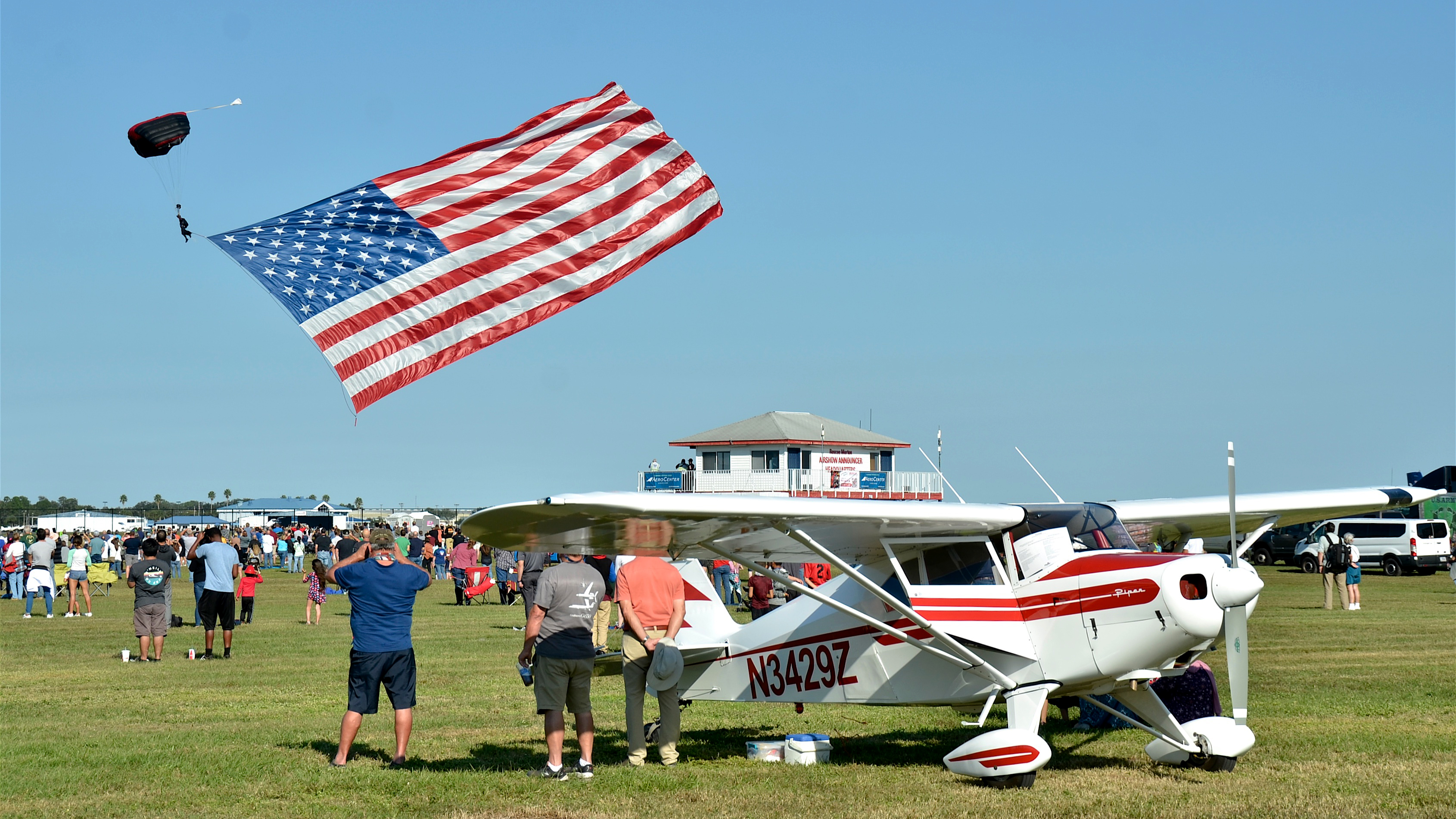 The U.S. Army Black Daggers special operations command parachute demonstration team opened the airshows on December 4 and 5 at the Sun ‘n Fun Holiday Flying Festival and Car Show. The conversion tailwheel Piper Tri-Pacer  in the foreground belongs to the Merritt Island Flying Club of Merritt Island, Florida. The AOPA Flying Clubs Initiative helped the group form, and today they have 17 members participating. Photo by Chris Eads.