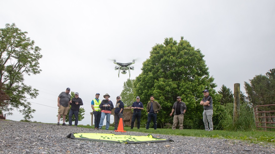Participants in a DARTdrones class held during an AOPA event in 2019 watch a DJI Phantom take off for a mapping mission. Photo by Jim Moore.