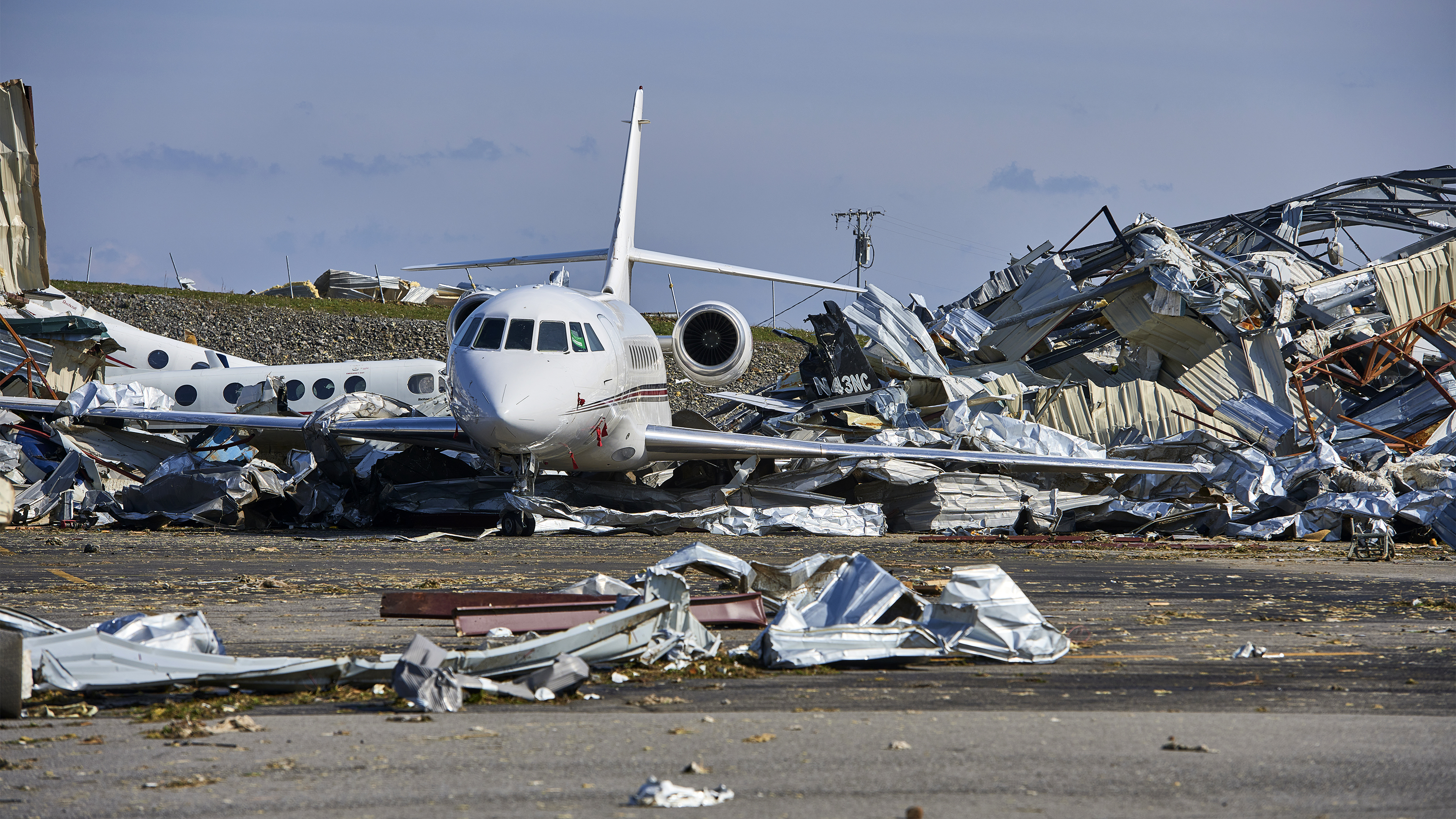 Hangar and aircraft debris surround a jet after a tornado struck John C. Tune Airport in Nashville. Photo by Harrison McClary.