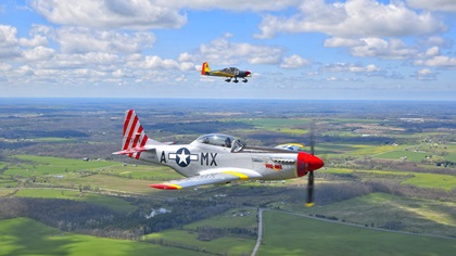 Lou Horschel's North American P–51 Mustang, "Mad Max," flies with the National Warplane Museum's Douglas C–47A near Bristol, New York, during Operation Thanks from Above. A Van's Aircraft RV–10 photo ship flown by Dan Maloney documents the event. Photo by Tetamore Photographic.