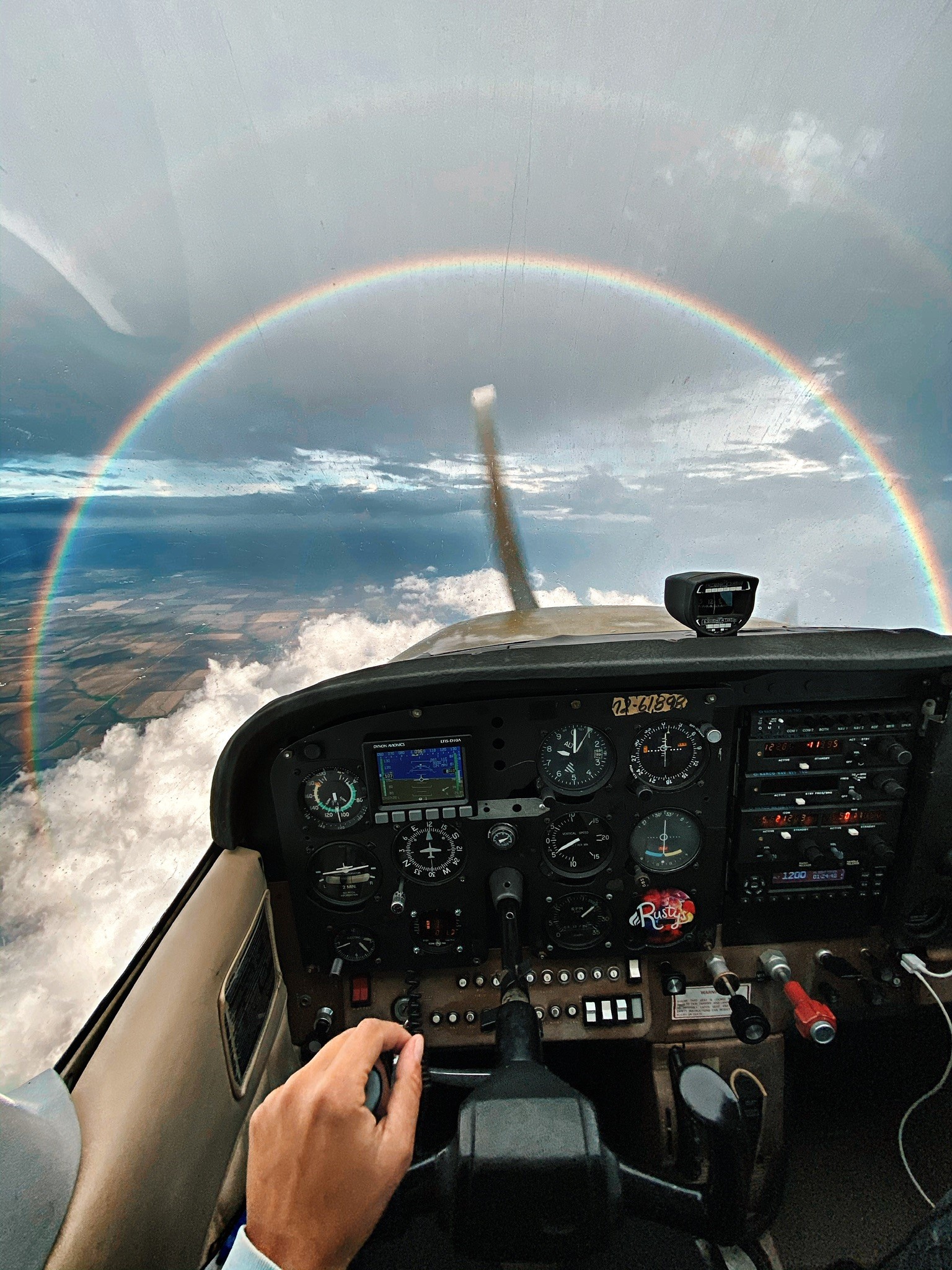 A rainbow arches across the windscreen of “Rusty,“ a Cessna 172, as Sarah Tamar and Filip Wolak fly across the country. Photo by Sarah Tamar.