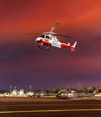 Under a smoke-darkened sky, a firefighting helicopter operates at Aurora State Airport in Aurora, Oregon. Photo by Aric Krause, courtesy of Van’s Aircraft. 