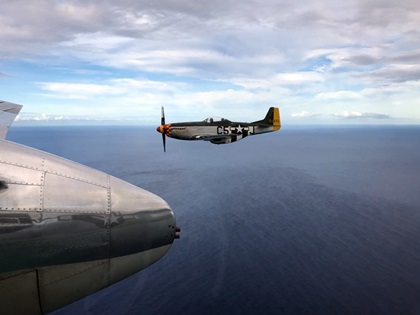 A North American P-51 Mustang forms up with "Old Glory." Photo courtesy of KT Budde-Jones.