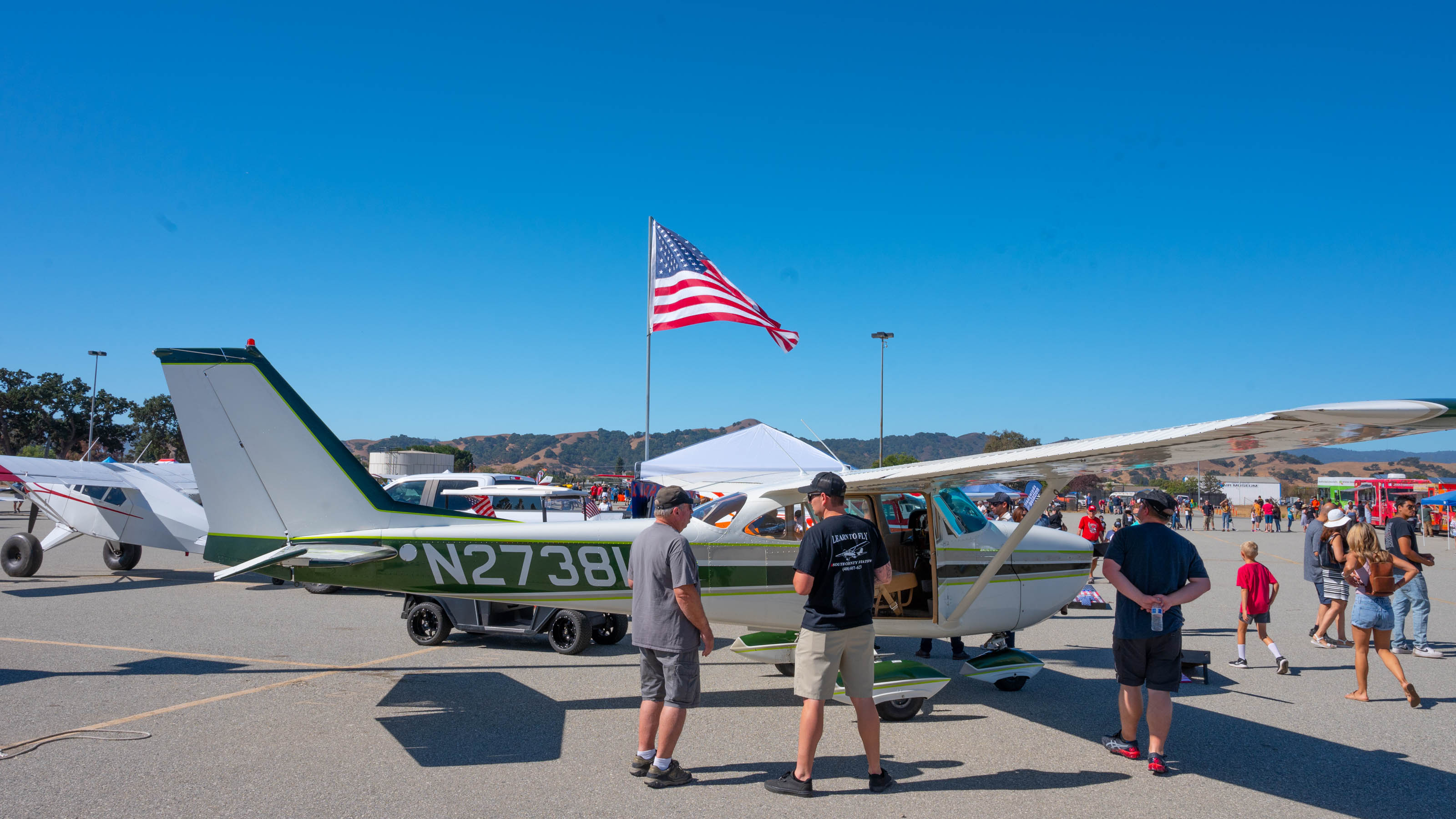 An American flag flies over South County Aviation's booth at the San Martin Airport's Food Truck Fly-In. Photo by Eric Peterson.