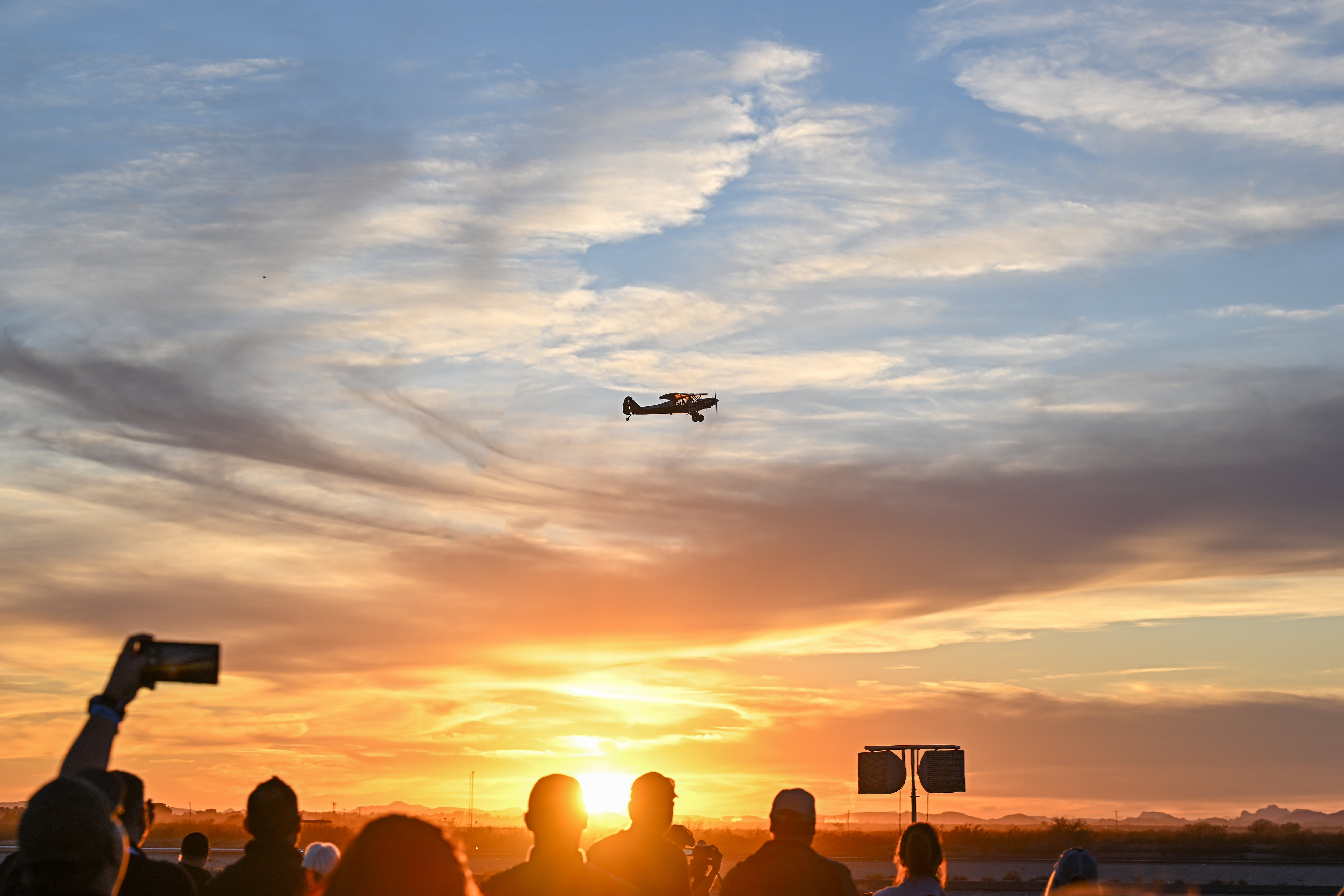 The setting sun frames Kyle Franklin performing a routine in front of the AOPA Flightline Chalet. Photo by David Tulis.