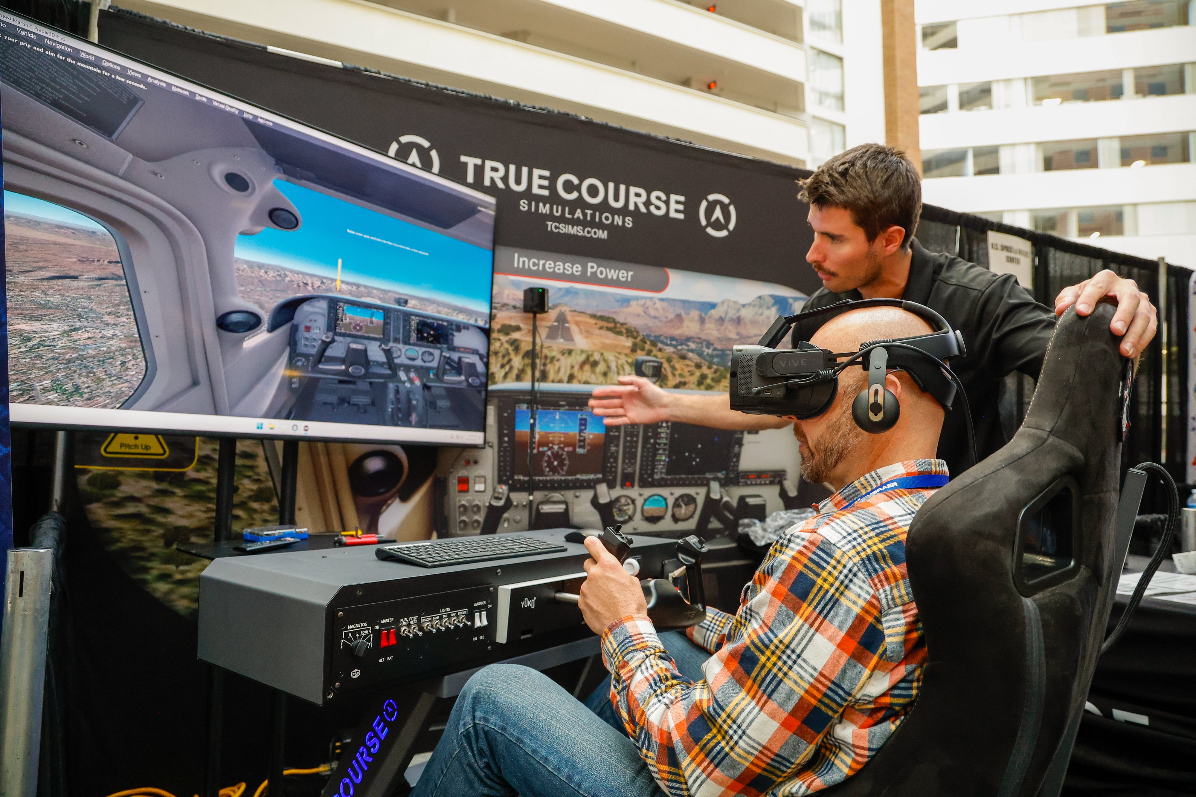 An attendee gets a hands-on experience at a simulator at the True Course Simulation exhibition booth. Photo by Chris Rose.