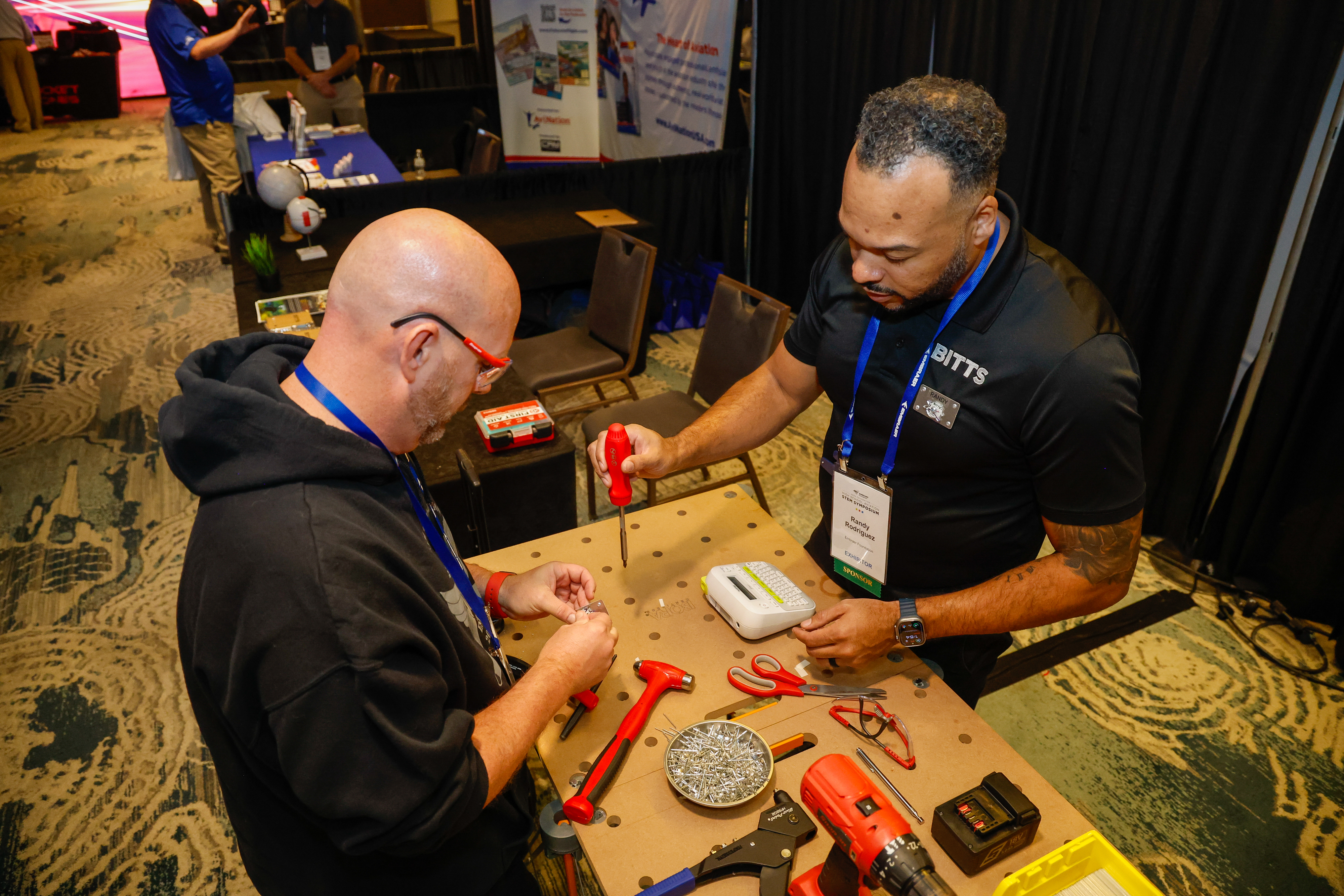 Randy Rodriguez gives a hands-on experience to an attendee at the Bitts exhibition booth. Photo by Chris Rose.