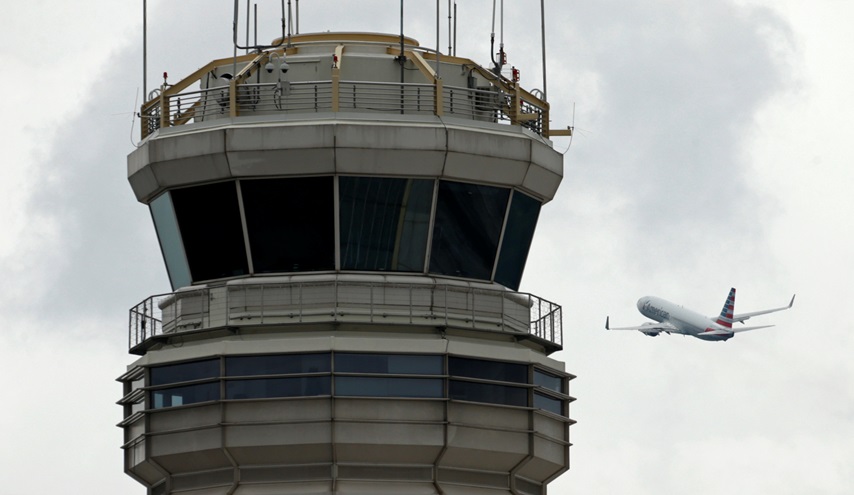 A plane passes the air traffic control tower at Ronald Reagan Washington National Airport in Arlington, Virginia, U.S., June 5, 2017.  REUTERS/Kevin Lamarque