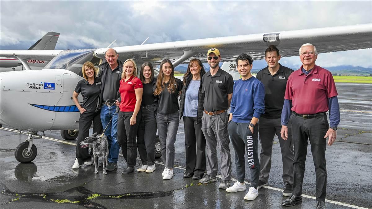 Kimberly Sanders Smith and Mike Smith (at left) with instructors, students, and the flight school dog, Gipsy.
