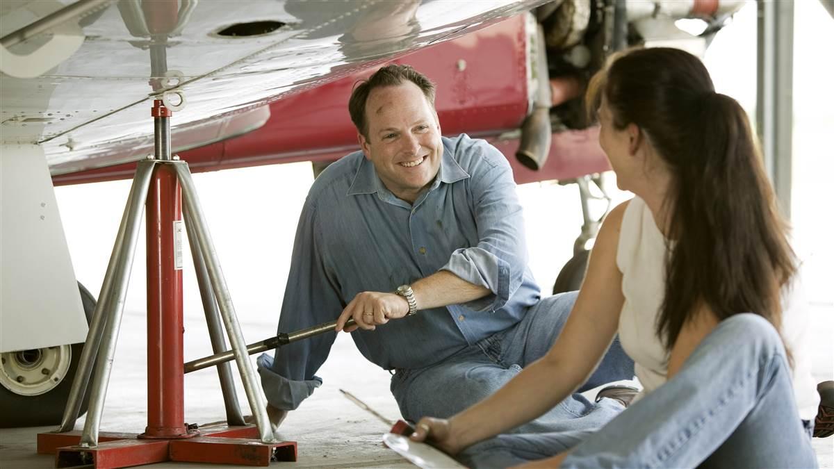 A husband and wife under the wing of their aircraft assisting the mechanic for their first annual inspection..Wichita,  KS  USAhttp://mikefizer.comImage #: 04-377_091.tif
