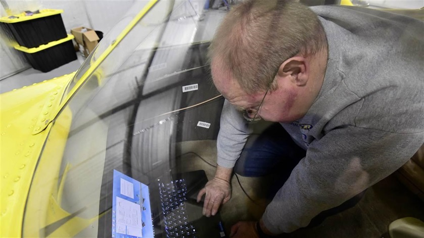 Airframe and powerplant mechanic Carlo Cilliers uses a laptop computer to configure a newly installed Garmin GDL 82 to make the aircraft compliant with the ADS-B Out mandate.