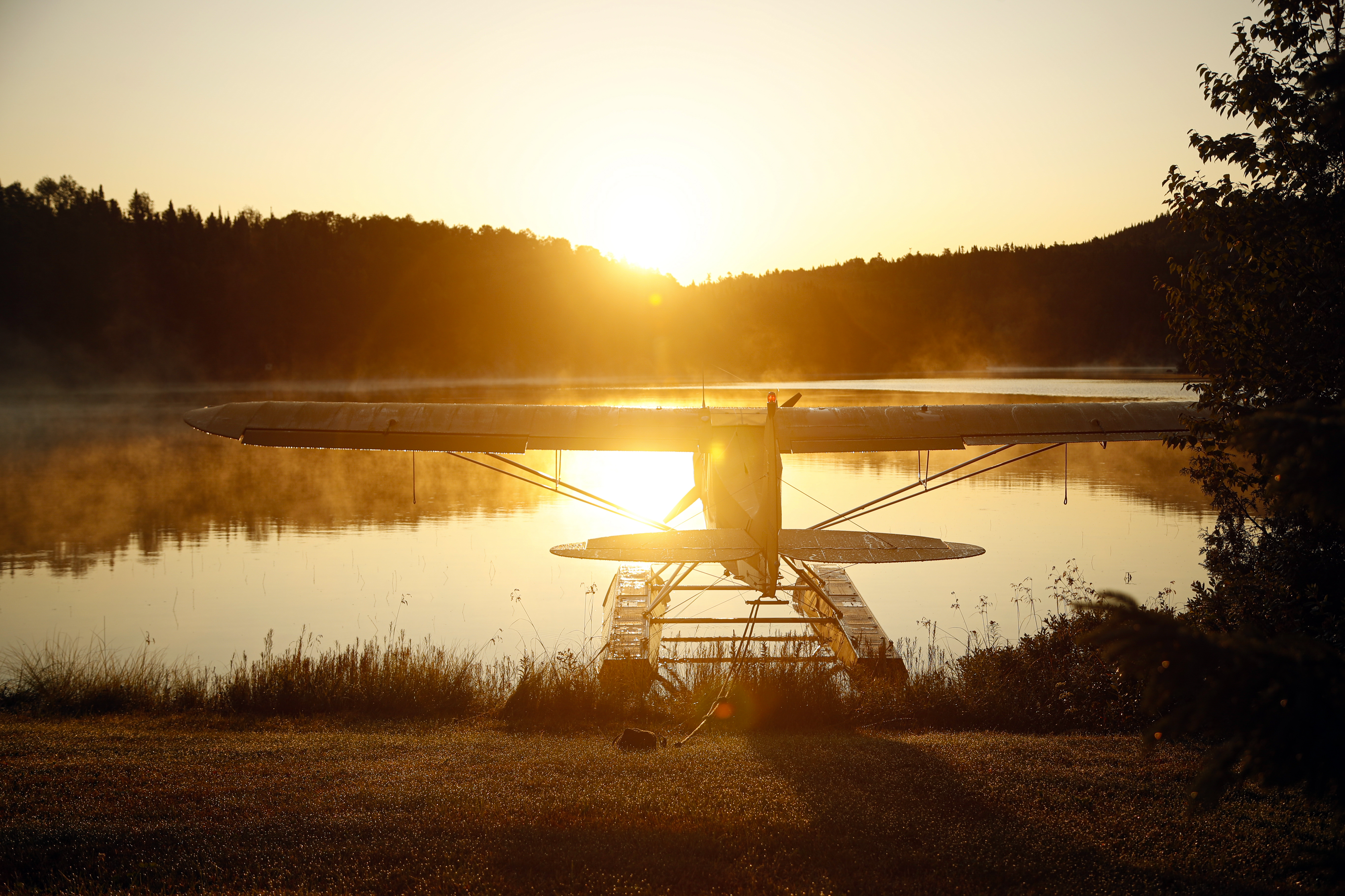 An amphibious Piper PA–18 Super Cub beached overnight is covered with dew at dawn.